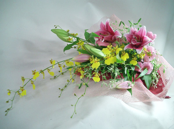 黄色の蘭 オンシジウムと優しいピンクの百合の花束です 豪華なイメージもありますので 贈呈用の花束 や ご結婚祝い お誕生日のお祝いなど 各種記念日などのフラワーギフトにどうぞ